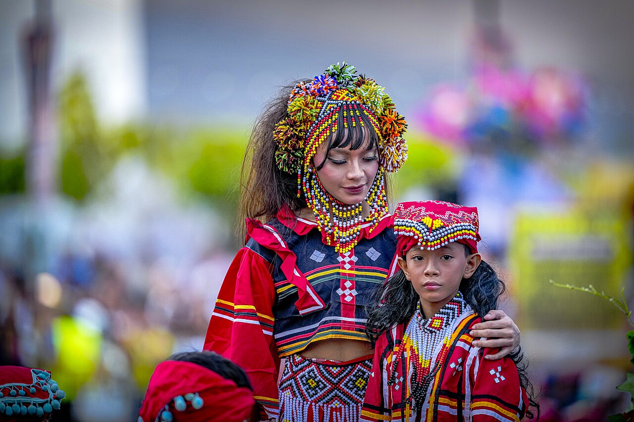2026年のカダヤワン祭で花とビーズの衣装を着た二人